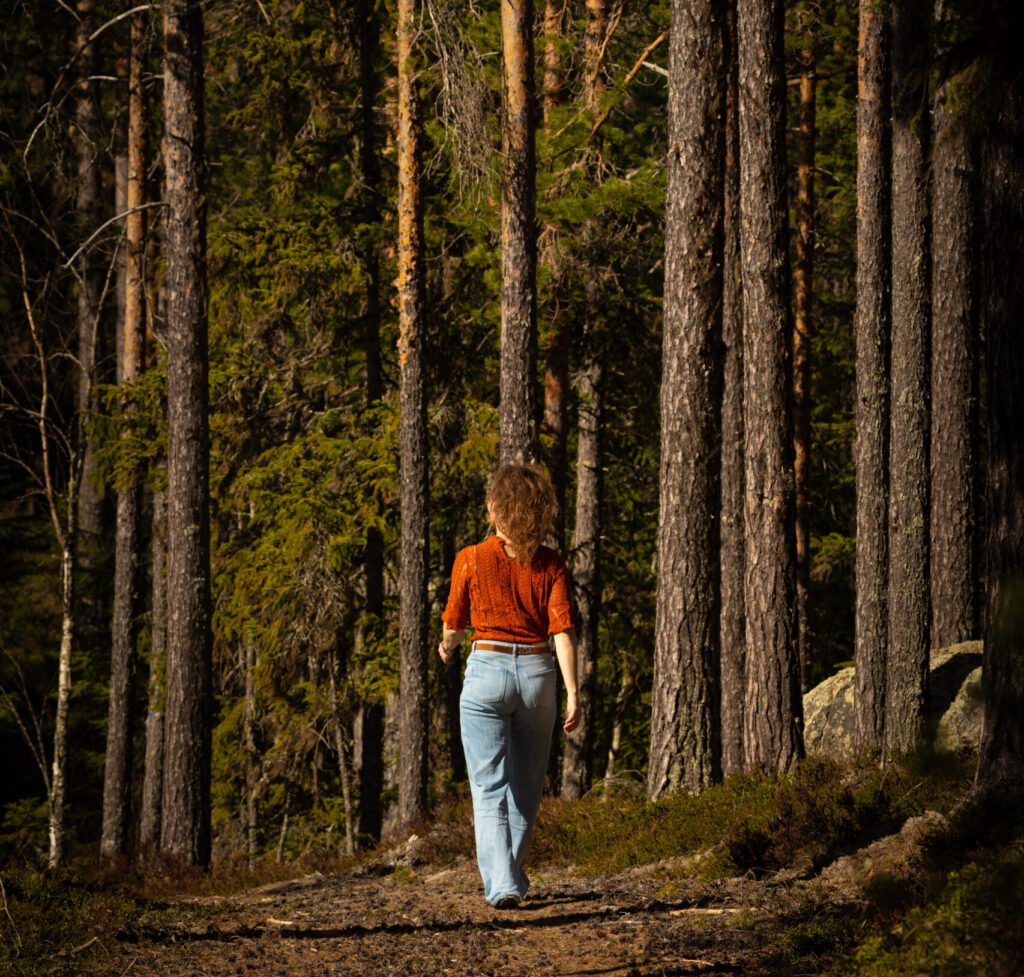 Een vrouw aan het wandelen tijdens Innertrail Woman in het bos in Zweden