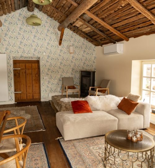 De woonkamer met bank en houtkachel bij Friluft Sweden. Waar InnerTrail Sweden plaatsvind