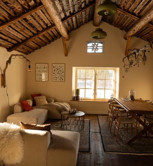 De gezellige zithoek en grote eettafel in het gastenverblijf Friluft Sweden